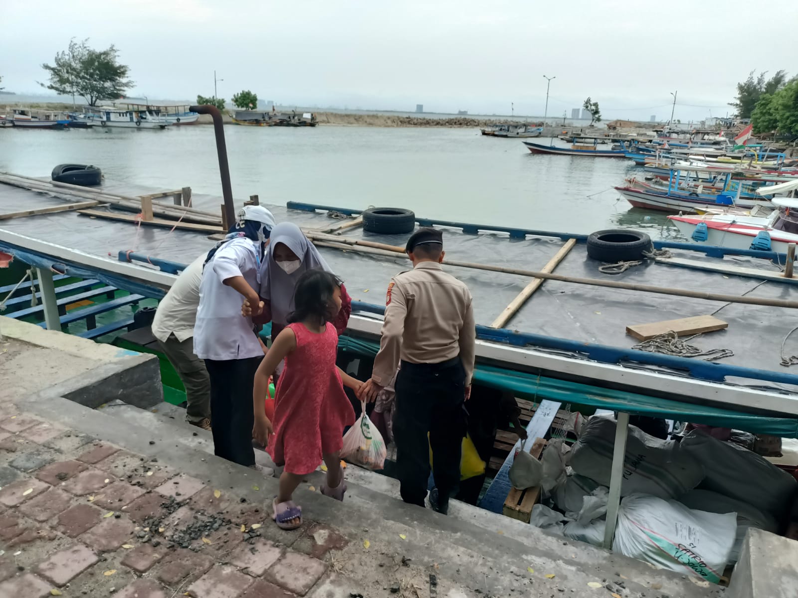 Polisi Baik Bantu Penumpang Turun dari Kapal, Pastikan Keamanan di Dermaga Pulau Untung Jawa