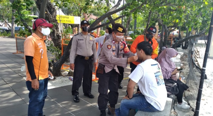Sambil Patroli di Pantai Beach Pool Ancol, Personil Polsek Pademangan Bagikan Masker ke Pengunjung