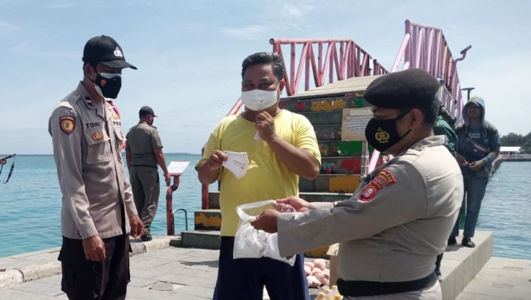 Dengan Berjalan Kaki, Personel Polsek Kep Seribu Selatan Sambangi Warga Himbau ProKes dan Bagikan Masker