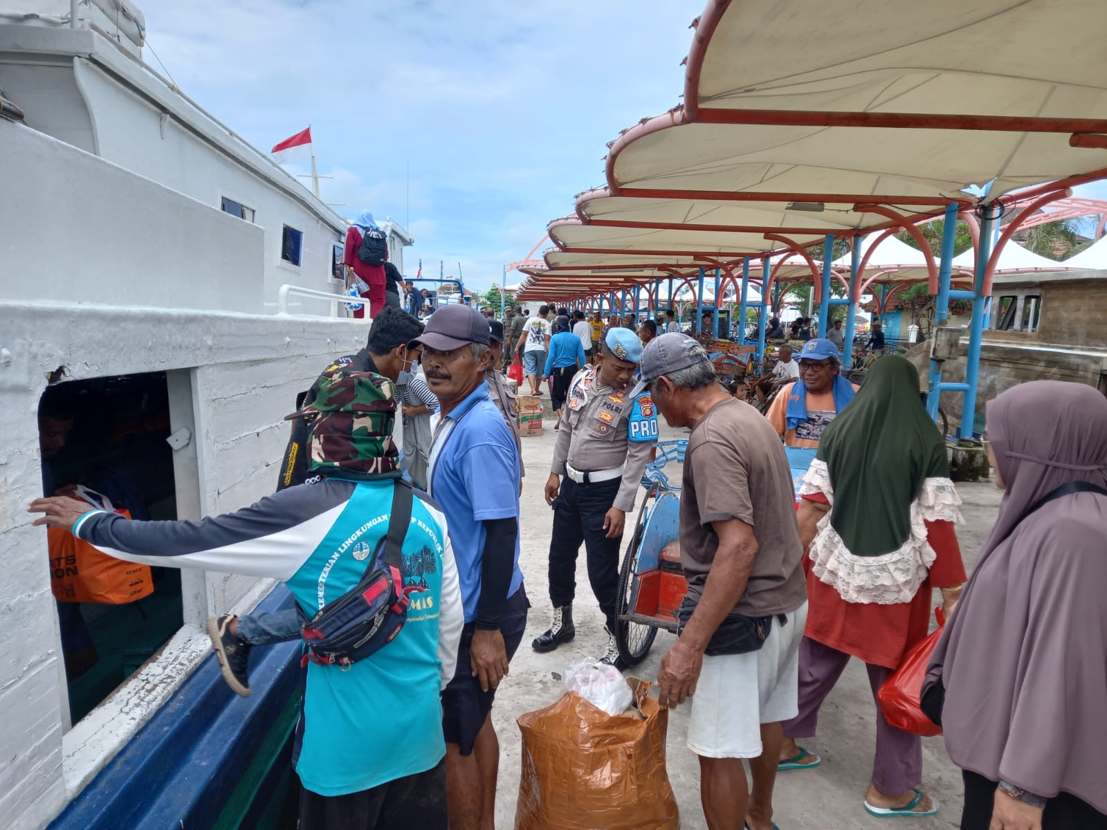 Polisi Baik Polsek Kepulauan Seribu Utara Bantu Penumpang Turun dari Kapal di Pulau Harapan