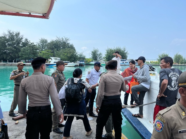 Polisi Baik Polsek Kepulauan Seribu Utara Bantu Penumpang Turun dari Kapal dalam Kegiatan Pengamanan Dermaga