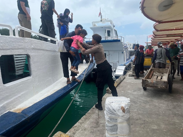 Polisi Baik dan Humanis Bantu Penumpang Turun dari Kapal di Dermaga Pulau Kelapa